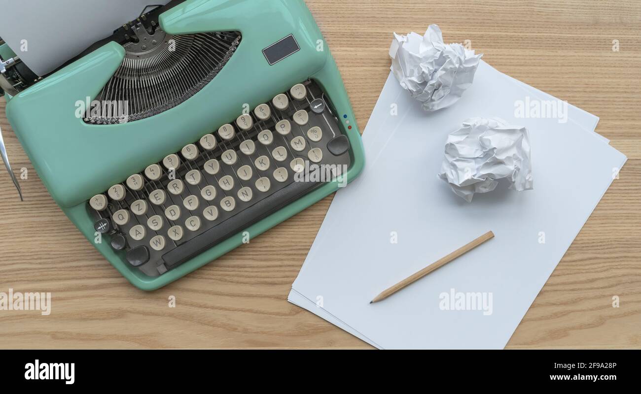 Eine Vintage-Schreibmaschine mit Papierblättern, Schablone und Papierkugeln. Stockfoto