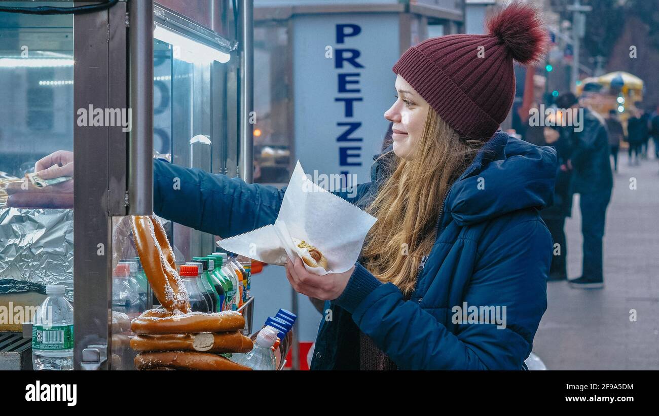 Junge Frau kauft einen Hot Dog in den Straßen von New York - Reisefotografie Stockfoto