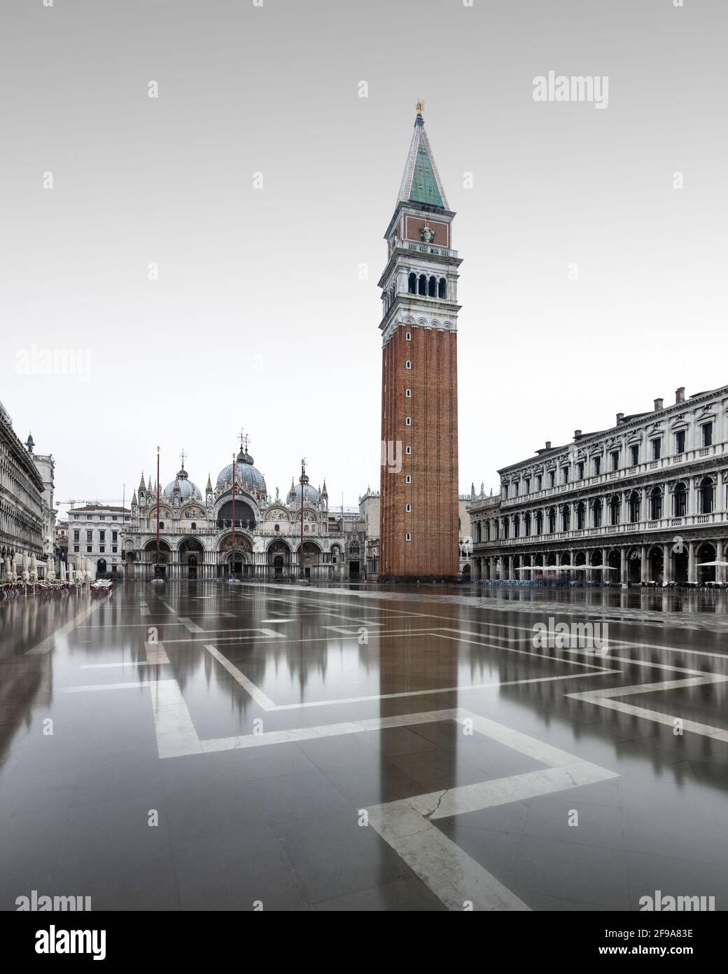 In den kühleren Wintermonaten überflutet die berühmte Flut, auch bekannt als Aqua Alta, regelmäßig den Markusplatz in Venedig und bietet wunderschöne Spiegelungen des campanile und der umliegenden Gebäude. Stockfoto