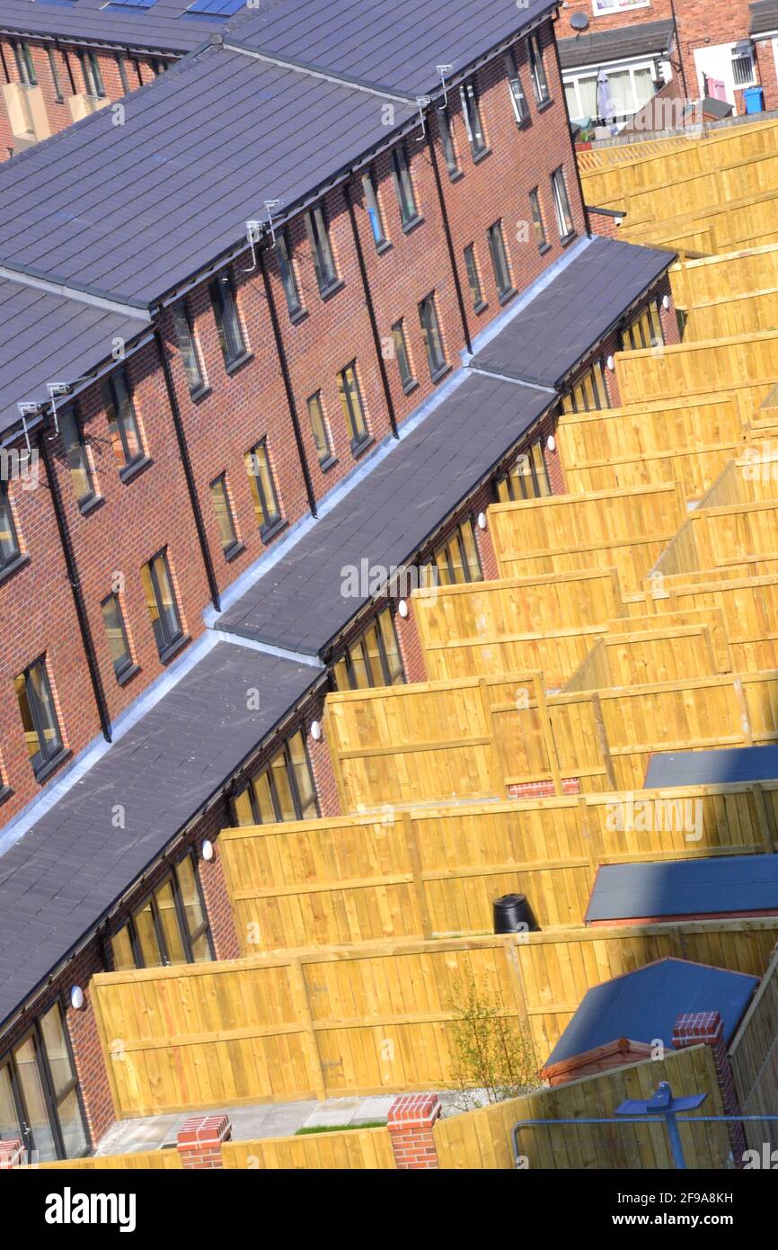 Blick von oben auf neue Häuser und ihre eingezäunten Hinterhöfe in Ardwick, Manchester, Großbritannien. Stockfoto
