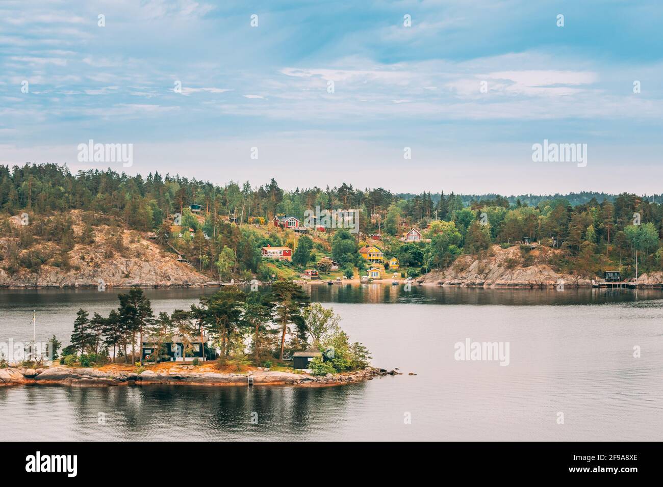 Schweden. Viele Schöne Schwedische Holzhütten Häuser An Der Rocky Island Küste Im Sommertag. See- Oder Flusslandschaft Stockfoto