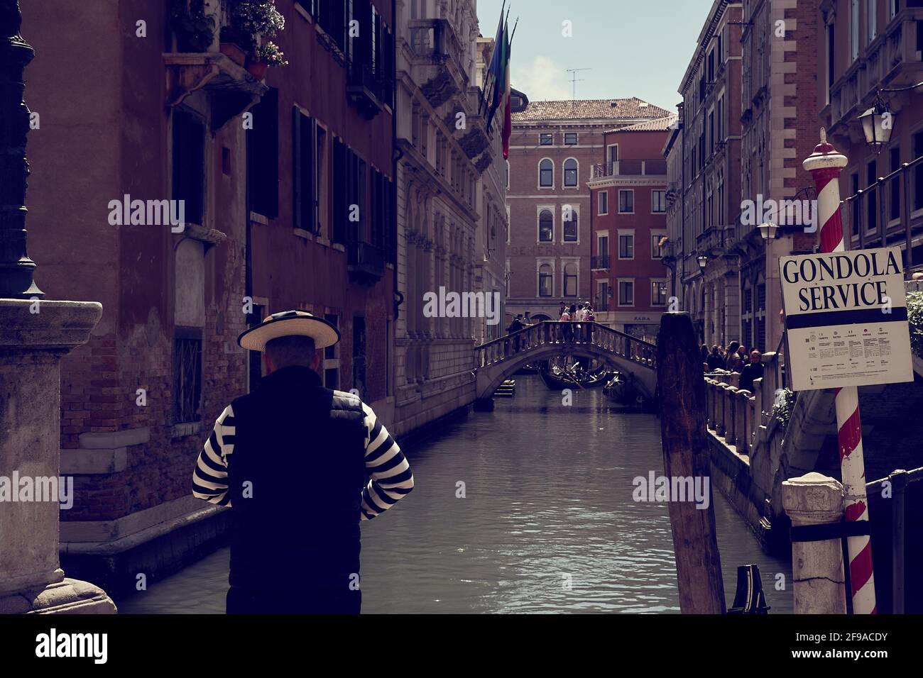Ein Gondolier wartet auf seinen nächsten Kunden an einem Gondolierpunkt in Venedig, Italien. Stockfoto