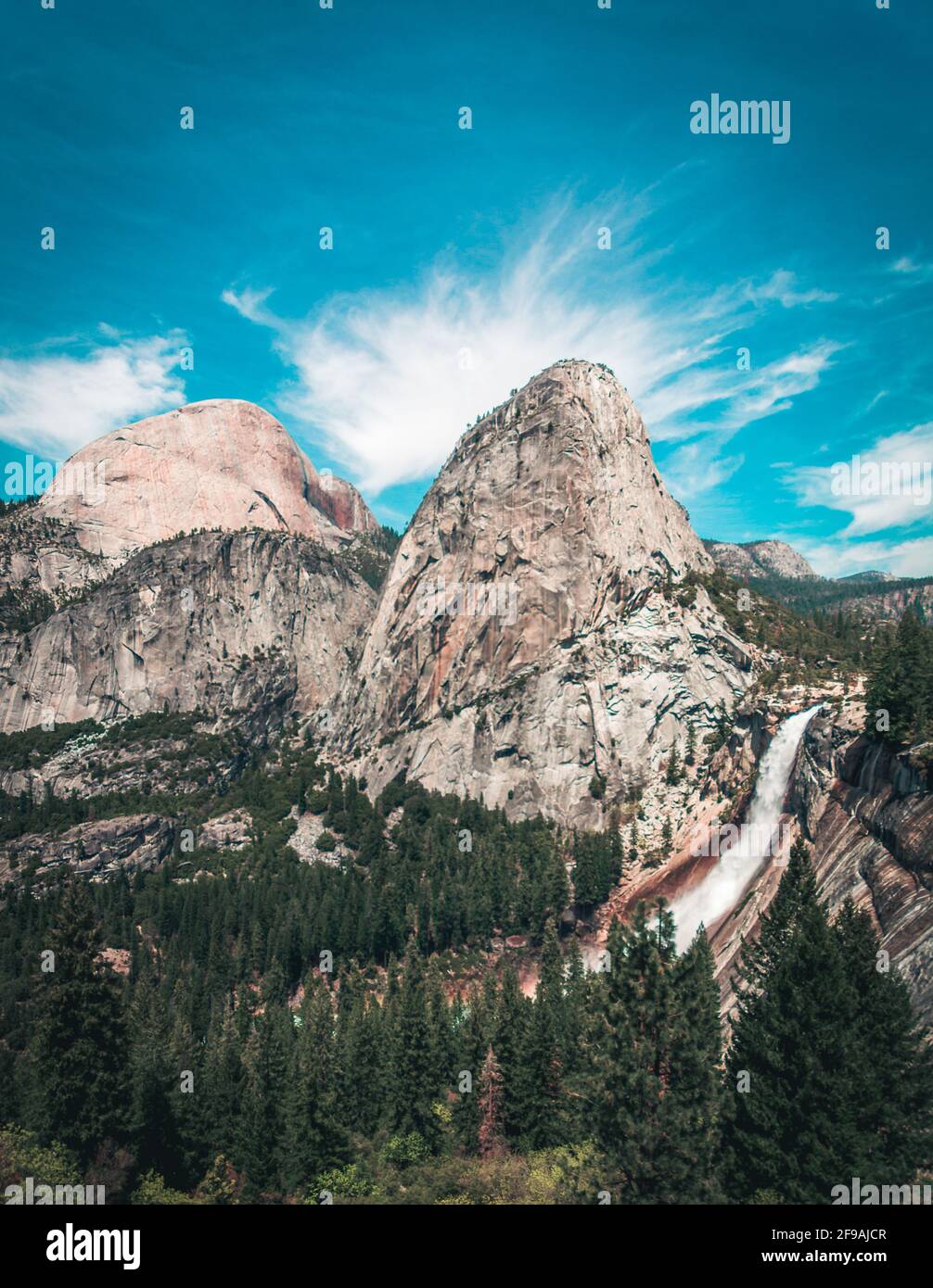 Half Dome mit den Sierra Mountains und Wasserfällen in der Entfernung Stockfoto