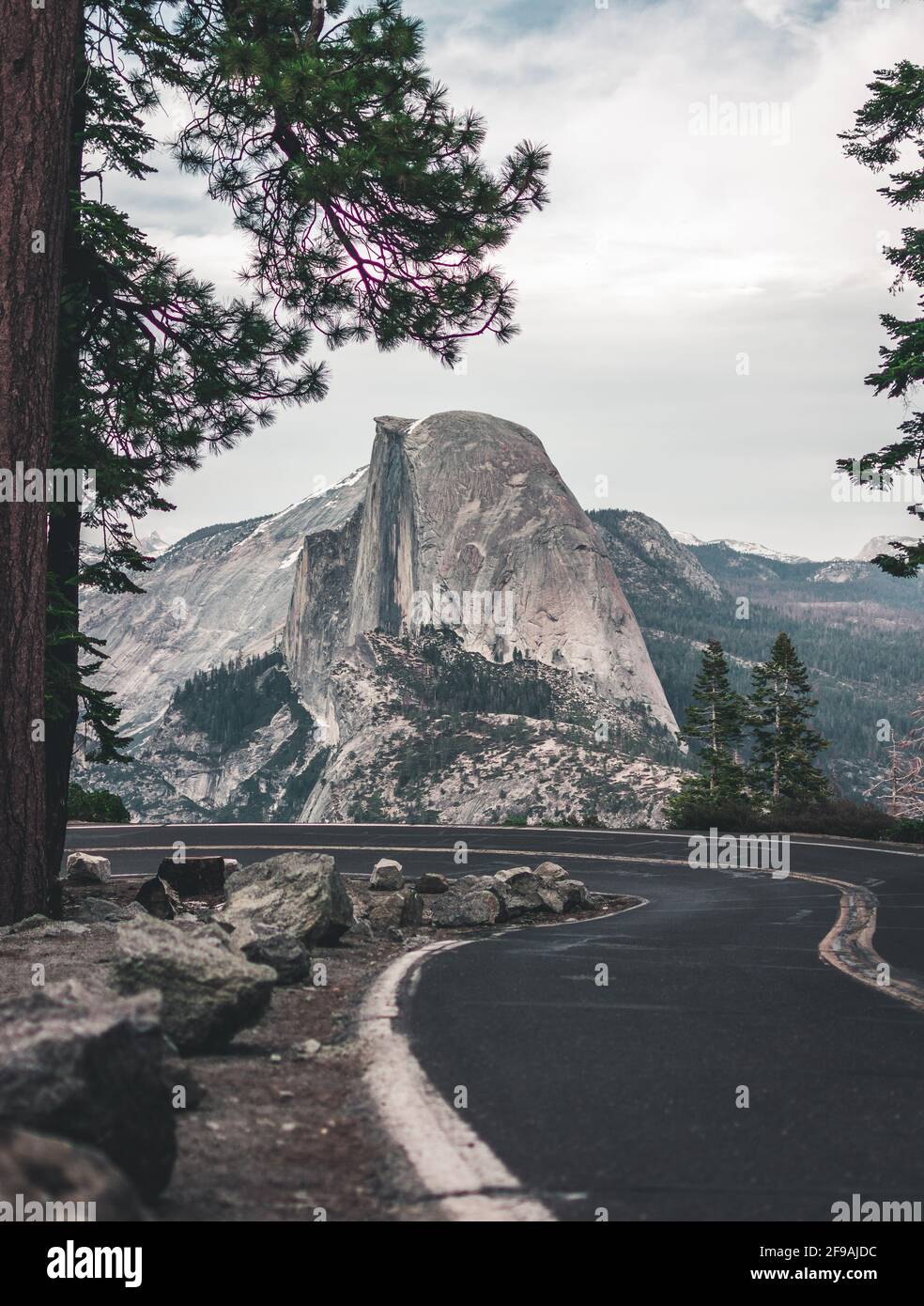 Wunderschöne Aussicht auf die verwinkelte Glacier Point Road mit dem berühmten Half Dome-Gipfel im goldenen Abendlicht bei Sonnenuntergang im Herbst, Yosemite National Park, Californi Stockfoto