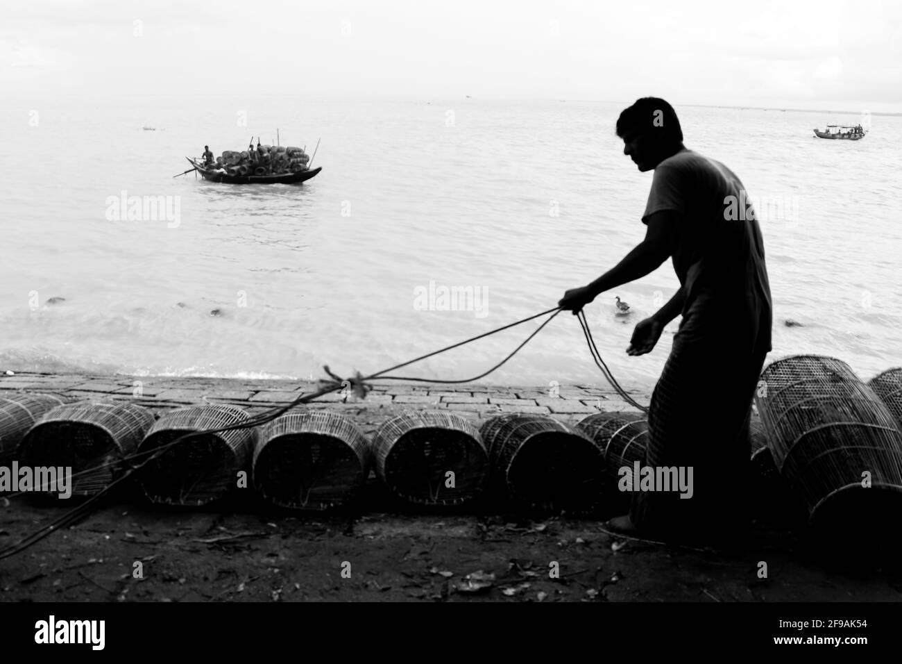 Fischer, der sich am Flussufer für das Fischen mit Käfig und Seil vorbereite Ich habe dieses Bild am 15. September 2020 aus Chandpur, Bangladesch, aufgenommen Stockfoto