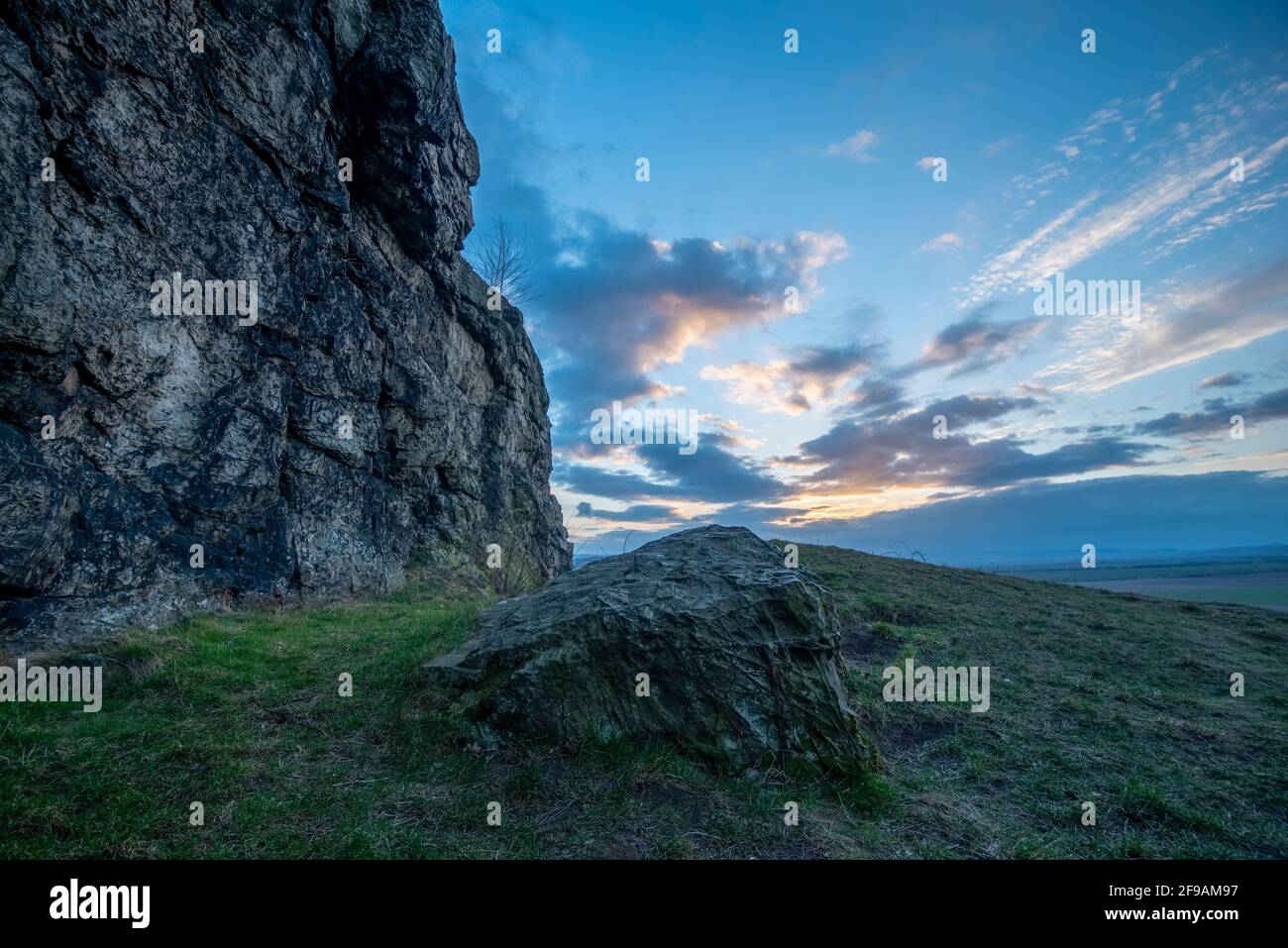 Deutschland, Sachsen-Anhalt, Ballenstedt, Sonne hinter dunklen Wolken, Gegensteine, Teil der Teufelsmauer im Harz. Stockfoto