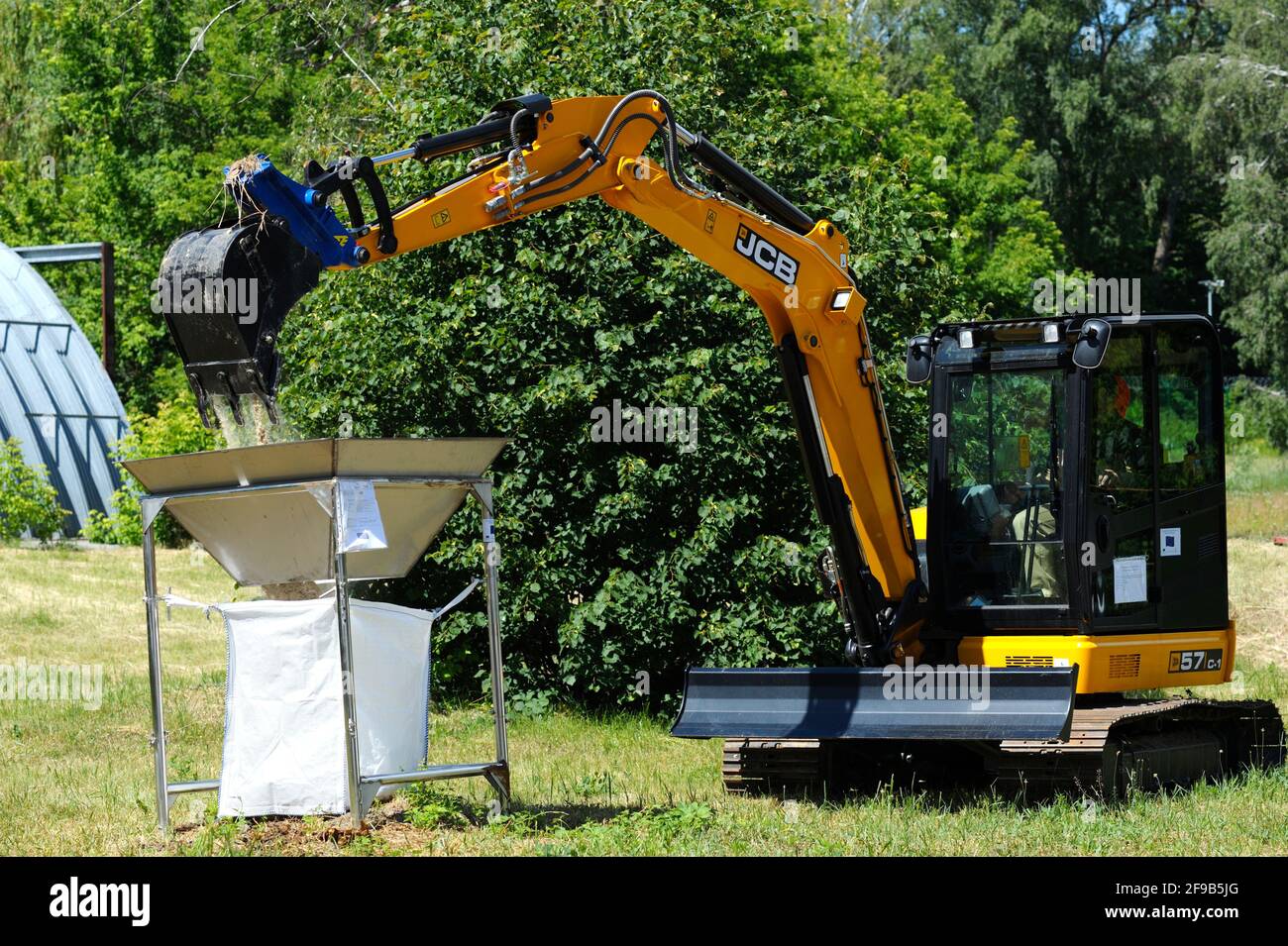 Bobcat verlädt Sand in einen Lagerbehälter für radioaktive Abfälle. Oktober 2018. Landesgesellschaft Radon . Kiew, Ukraine Stockfoto