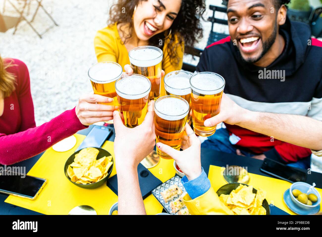 Gruppe multikultureller Freunde, die in der Brauerei Bier trinken und toasten Bar-Restaurant - Glückliche Menschen, die Spaß auf dem Dach haben Party - Fokus auf Brille Stockfoto