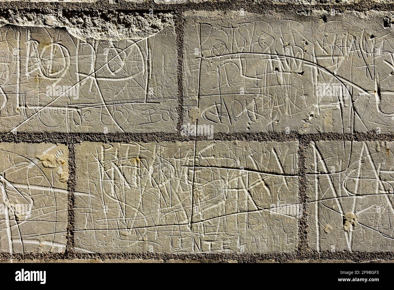 Namen und Initialen, die in Steinmauern zerkratzt wurden - Loches, Indre-et-Loire, Frankreich. Stockfoto