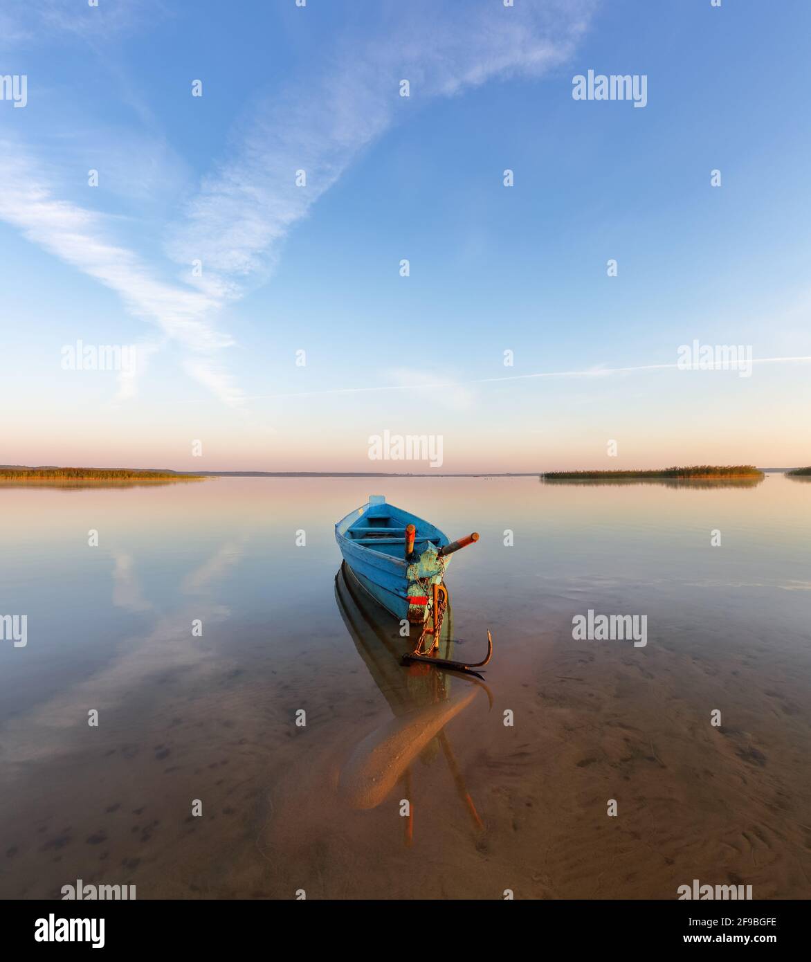 Einsames Boot im ruhigen See. Die Silhouette spiegelt sich auf dem Wasser. Schöner Sommertag. Unglaublicher Sonnenaufgang. Blauer Himmel mit Wolken. Lage, Hotel Svity Stockfoto