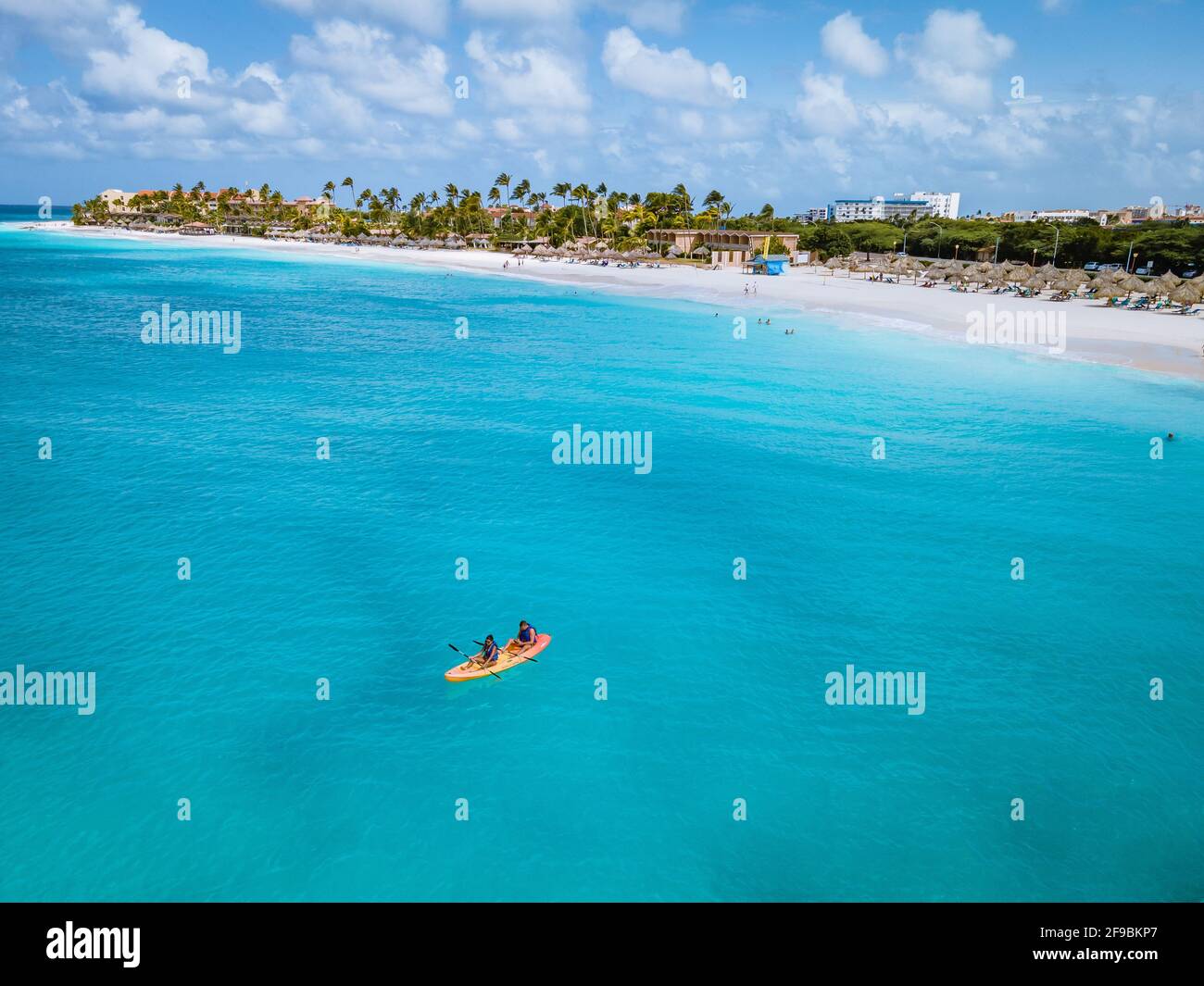 Paar Kajakfahren im Meer auf Urlaub Aruba Karibisches Meer, Mann und Frau mittleren Alters Kajak im Ozean blauen Clrea Wasser weißen Strand und Palmen Aruba Stockfoto