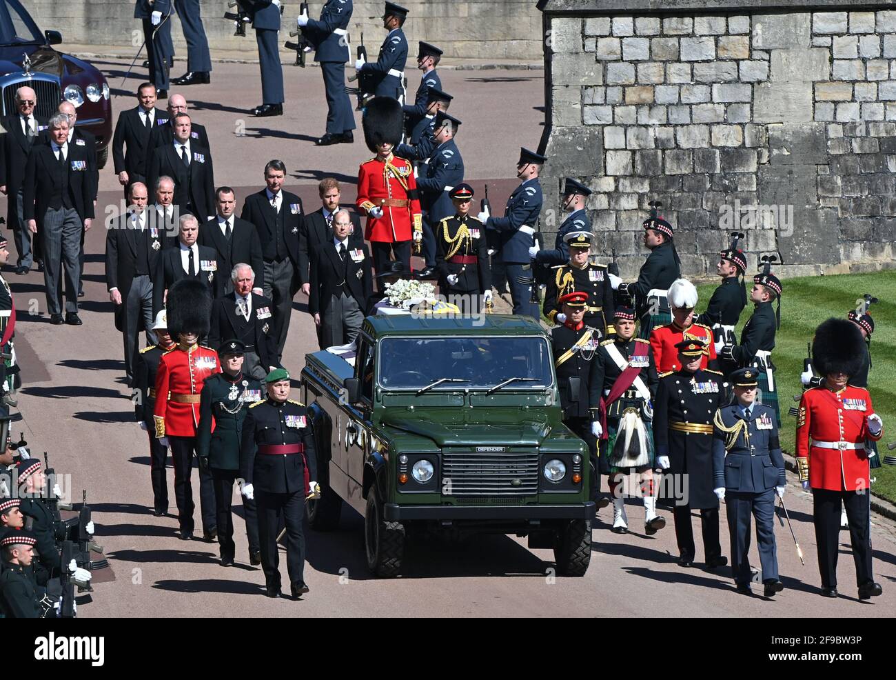 Der Sarg des Herzogs von Edinburgh, der mit seinem persönlichen Standard bedeckt ist, wird auf dem eigens gebauten Land Rover Defender getragen, gefolgt von der Prinzessin Royal, dem Prinz von Wales, dem Herzog von York, dem Earl of Wessex, dem Herzog von Cambridge, Peter Phillips, dem Herzog von Sussex, dem Earl of Snowdon, Vize-Admiral Sir Timothy Laurence vor der St. George's Chapel, Windsor Castle, Bestattungsanstellung des Herzogs von Edinburgh. Bilddatum: Samstag, 17. April 2021. Stockfoto