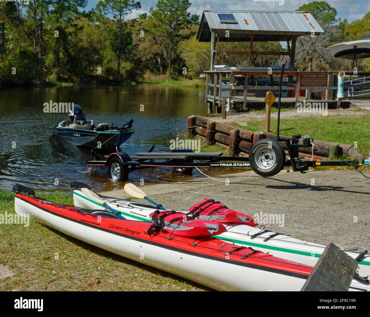 Bootsrampe, eingesteckt, kleines Motorboot im Wasser, Anhänger, 2 Kajaks warten, Fischreinigungsstation, Erholung, Freizeit, Sport, Lake Kissimmee State Park, Stockfoto