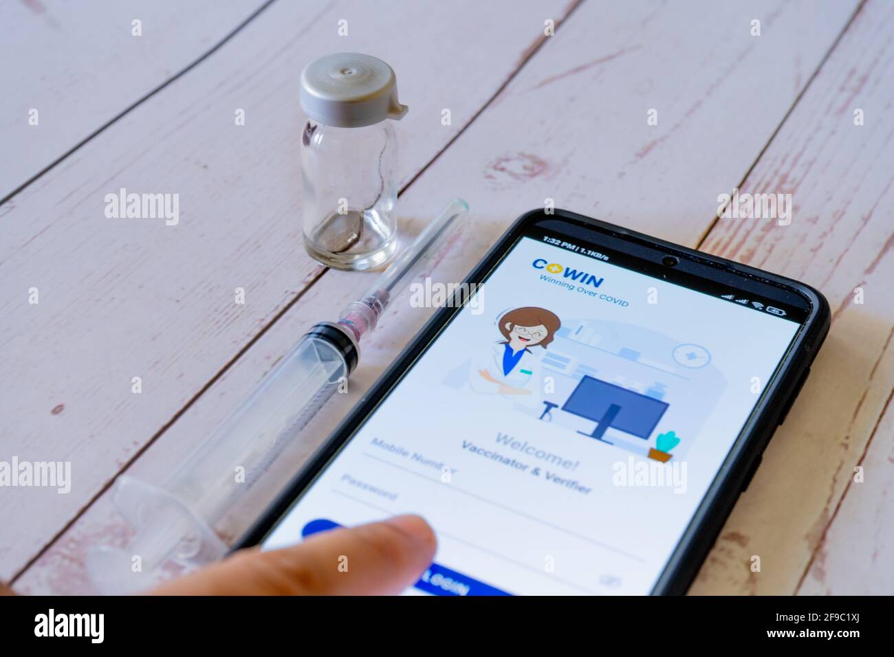 Mann Arzt zeigt auf Co-WIN App Anwendung während der Impfung Mit einer Spritze und einem Fläschchen wird als Covishield Covaxin verabreicht Während des Stockfoto