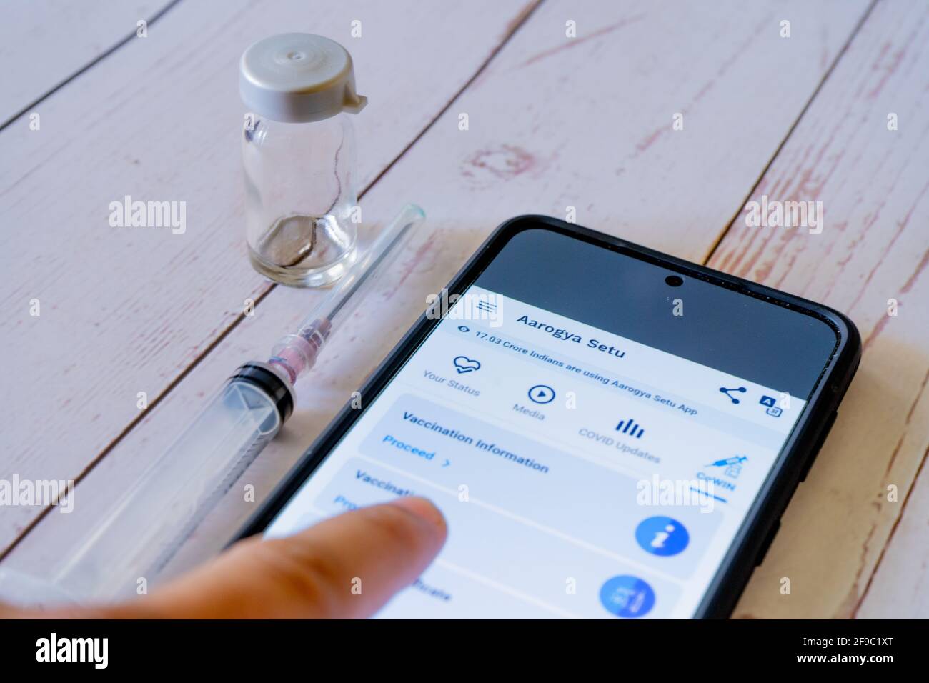 Mann Arzt zeigt auf arogya setu App Co-WIN, während bekommen Geimpft mit Covaxin Covishield mit Spritze und Fläschchen zur Nachverfolgung Immunität während Stockfoto