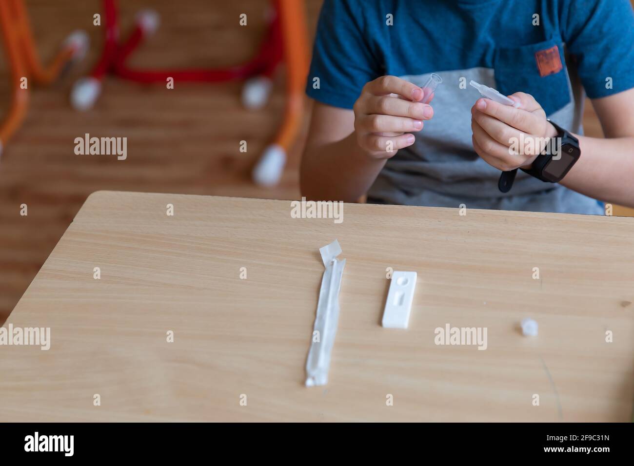 Der Junge wird vor der Klasse auf covid-19 getestet. Stockfoto
