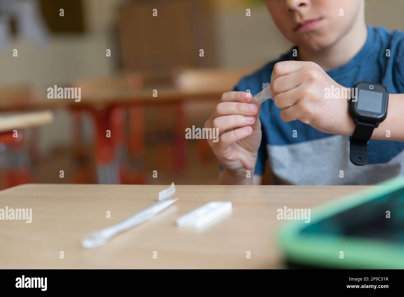 Der Junge wird vor der Klasse auf covid-19 getestet. Stockfoto
