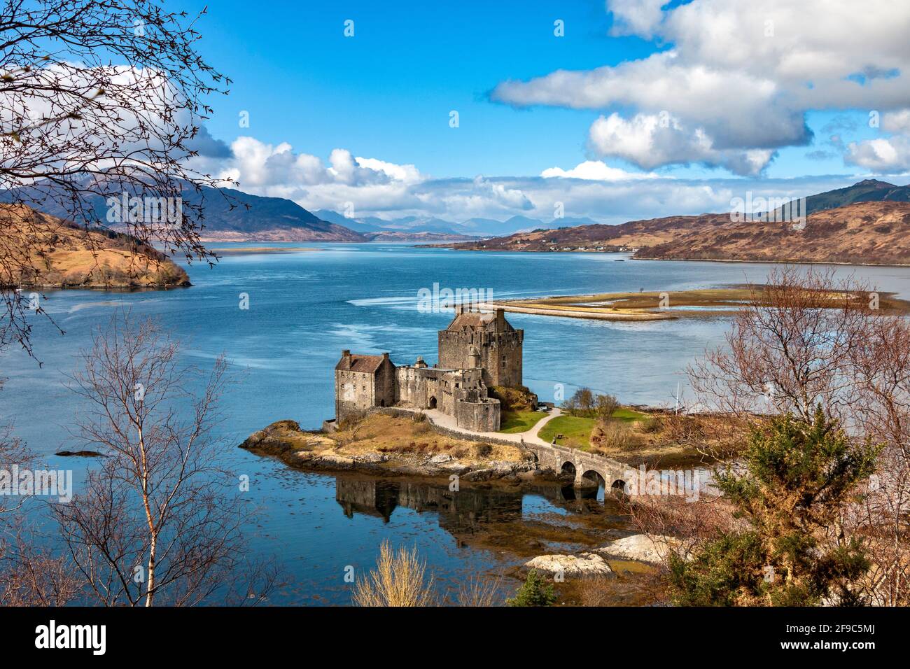 EILEAN DONAN CASTLE LOCH DUICH HIGHLANDS SCHOTTLAND BLAUER HIMMEL UND EIN BLAUES LOCH IM FRÜHLING SCHNEEBEDECKTE BERGE IN DER ENTFERNUNG Stockfoto