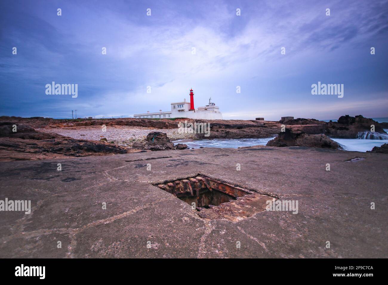 Leuchtturm an einem felsigen Strand an einem bewölkten Wintertag. Stockfoto