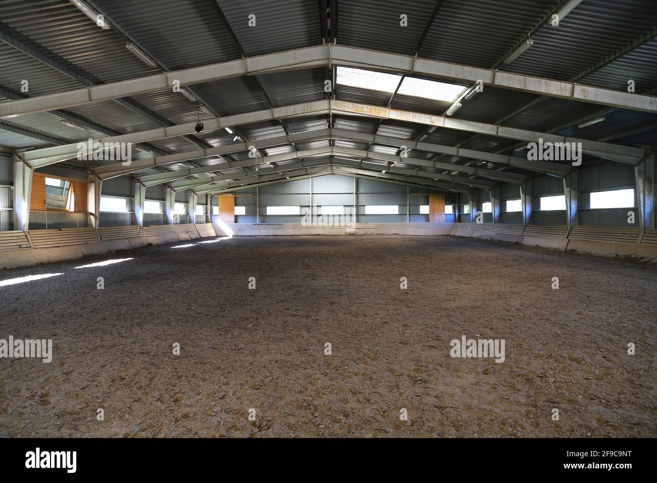 Foto einer leeren Reithalle für Pferde und Reiter. Die Reitschule ist für Dressur- und Springpferde den ganzen Tag geeignet Stockfoto