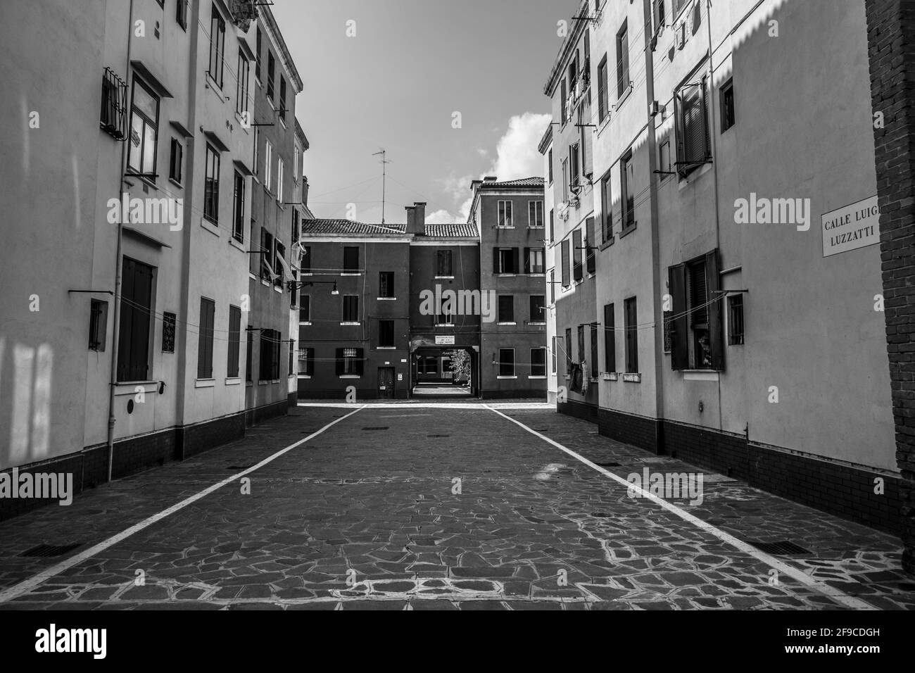 Graustufenaufnahme einer Straße zwischen zwei Gebäuden in Venedig, Italien Stockfoto