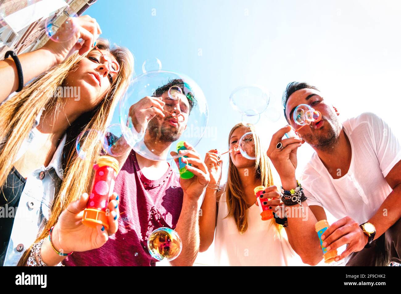 Junge Freunde, die im Frühling mit Seifenblasen spielen Pausenzeit - Freundschaftskonzept und echter Lebensstil mit Glückliche, tausendelfmütigen Menschen Stockfoto
