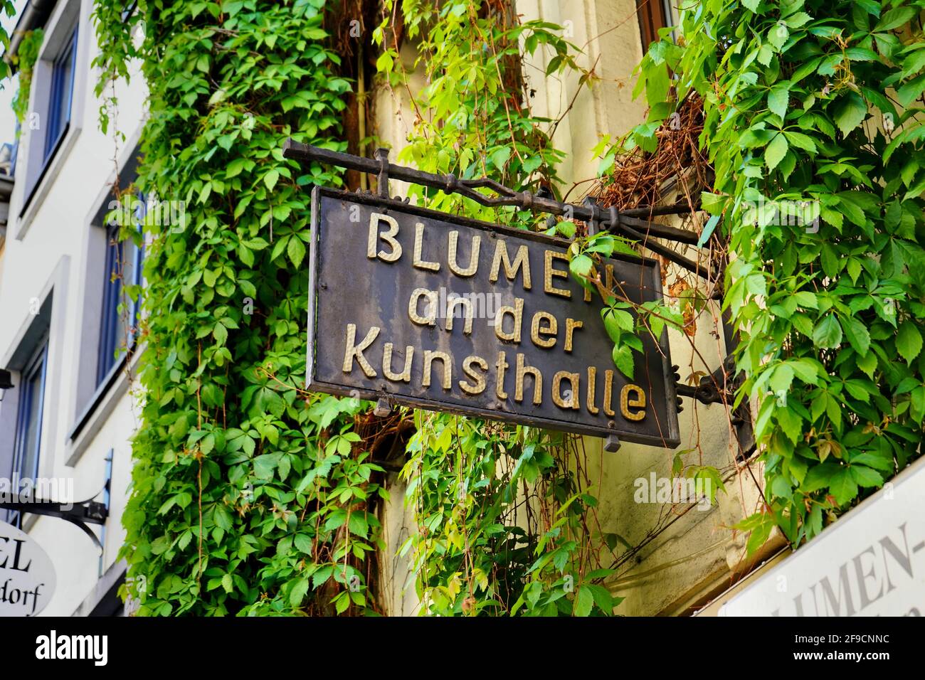 Schaufelschild eines einzigartigen Geschäfts für Blumen und Wohndekorationen im beliebten Touristenviertel der Düsseldorfer Altstadt. Stockfoto