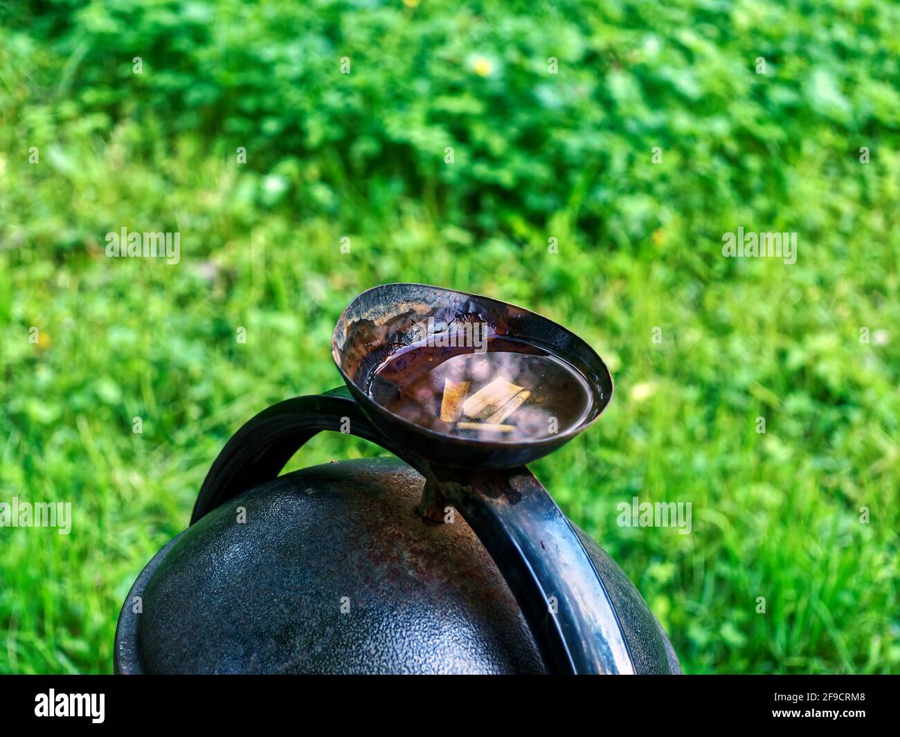Zigarettenkippen treiben im Sommer in einer Urne auf der Straße Stockfoto