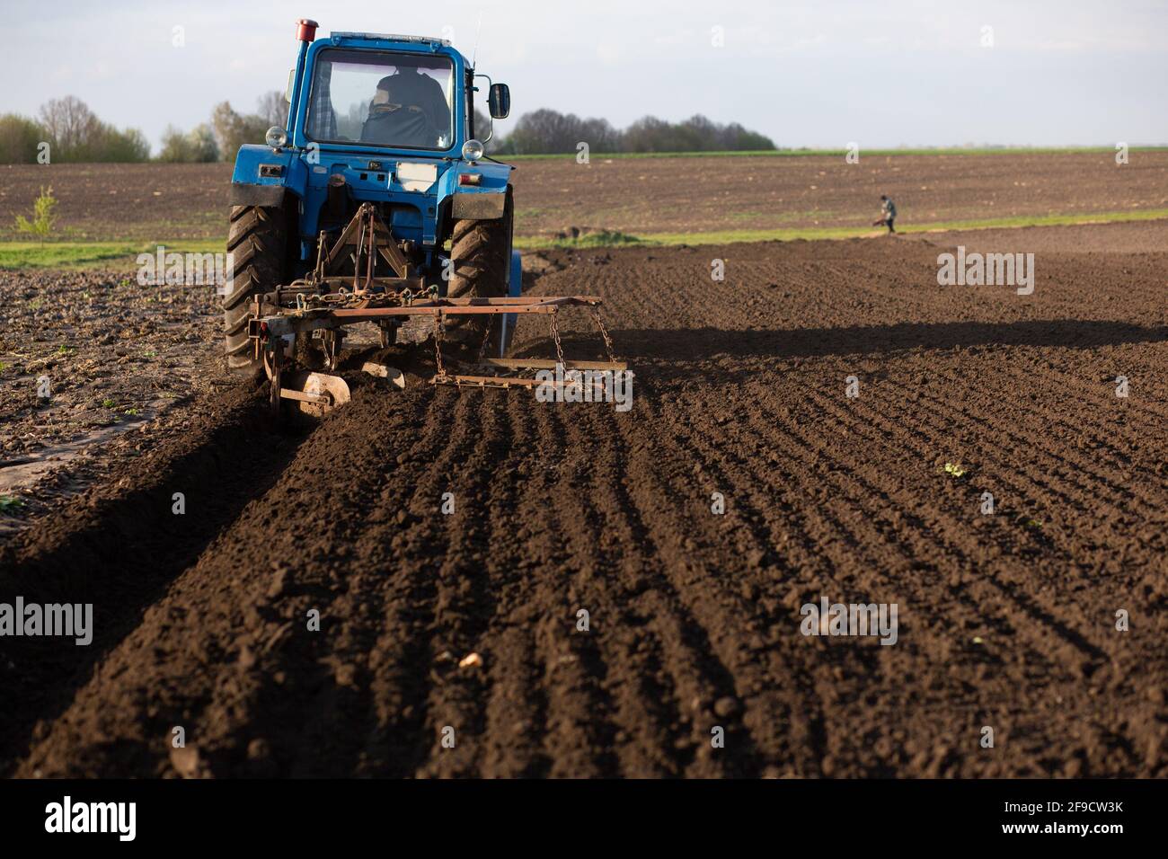 Ein alter blauer Traktor pflügt das Land. Ort für Ihren Text Stockfoto