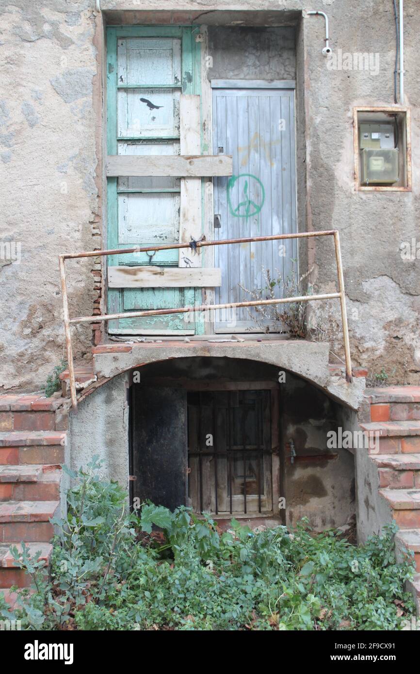 Verlassene geschlossene Tür, mit Treppe, Balkon, Geländer, Sicherungskasten und einem Friedenszeichen auf einer Holztür Stockfoto