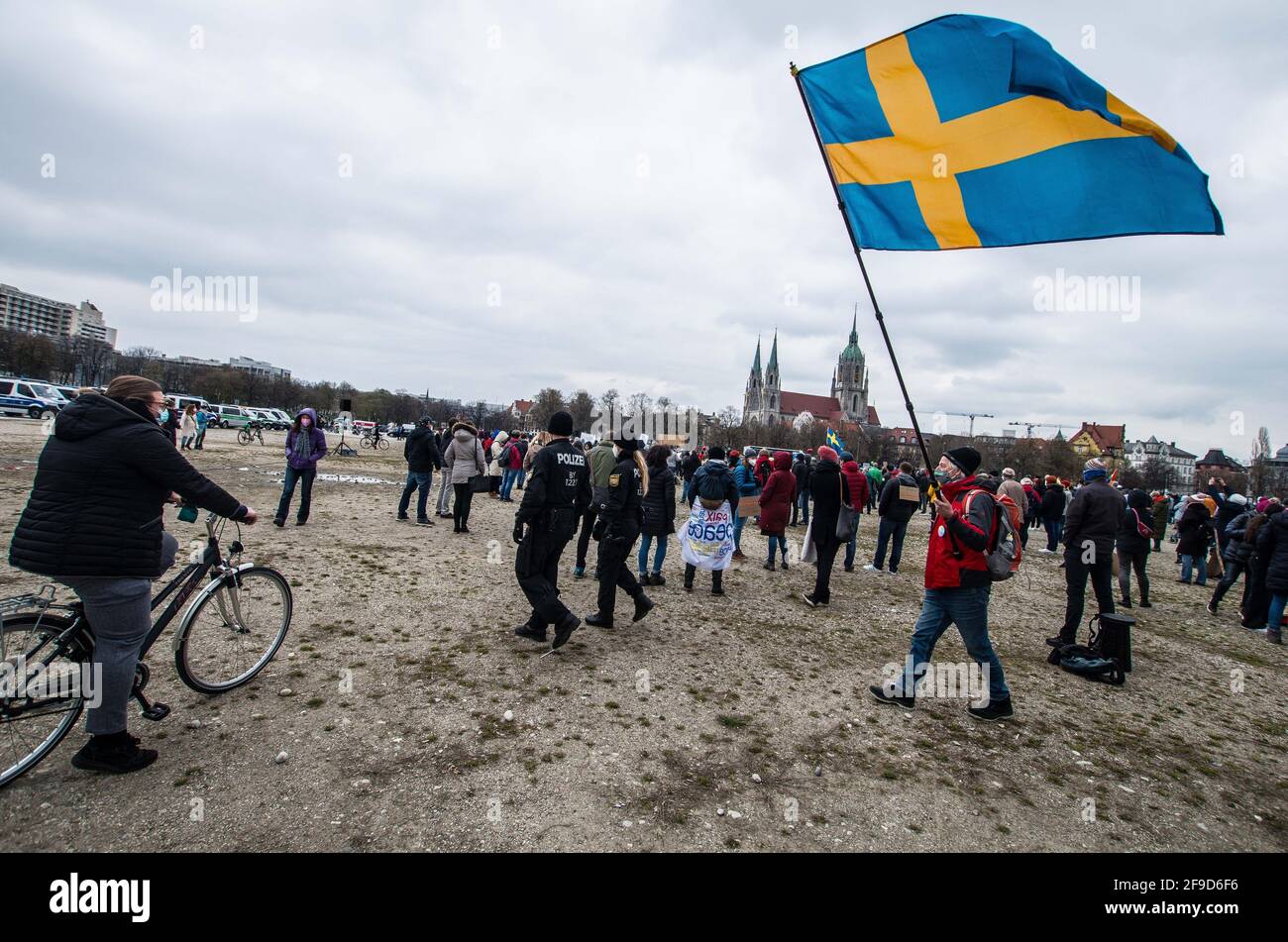 München, Bayern, Deutschland. April 2021. Ein Corona-Rebell folgt der Polizei für längere Zeit mit einer schwedischen Flagge. Nach Wochen stetiger Radikalisierung und Entlarvung in den Netzwerken alliierter Verschwörungstheoretiker, Anti-Vaxxer, Corona-Leugner, Reichsbuerger (souveräne Bürger), New Age und Konspirituality hielten die Basis, Querdenken und Bayern steht Zusammen-Gruppen eine Kundgebung auf der Münchner Theresienwiese ab. Interne Streitigkeiten in den letzten Wochen haben auch dazu geführt, dass einige die Querdenken-Gruppe verlassen haben, die versucht hat, eine vorherrschende „Querdenkkraft“ und parteiübergreifende Kraft in Form von Tod zu werden Stockfoto