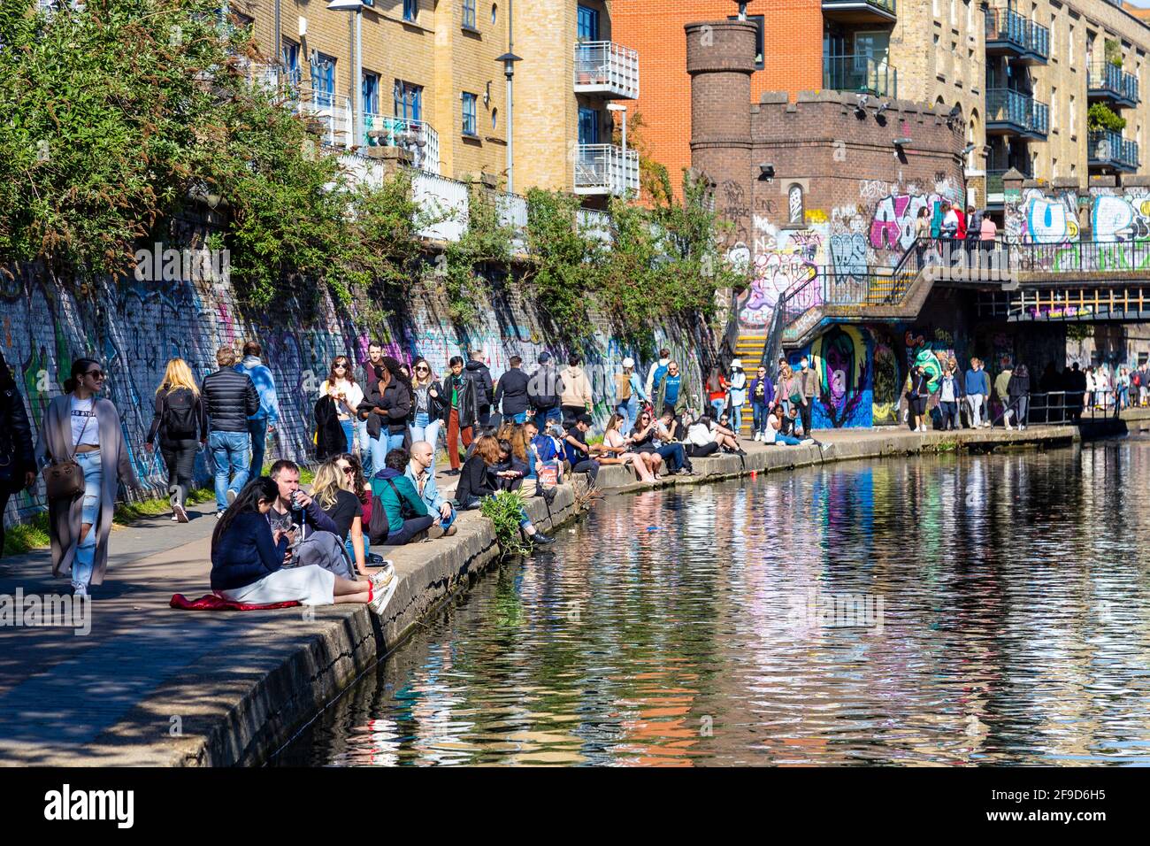 17. April 2021 - London, Großbritannien, Menschen, die an einem sonnigen Wochenende am Regents Canal in der Nähe des Camden Market sitzen, nachdem die Sperrung der Coronavirus-Pandemie gelockert wurde Stockfoto