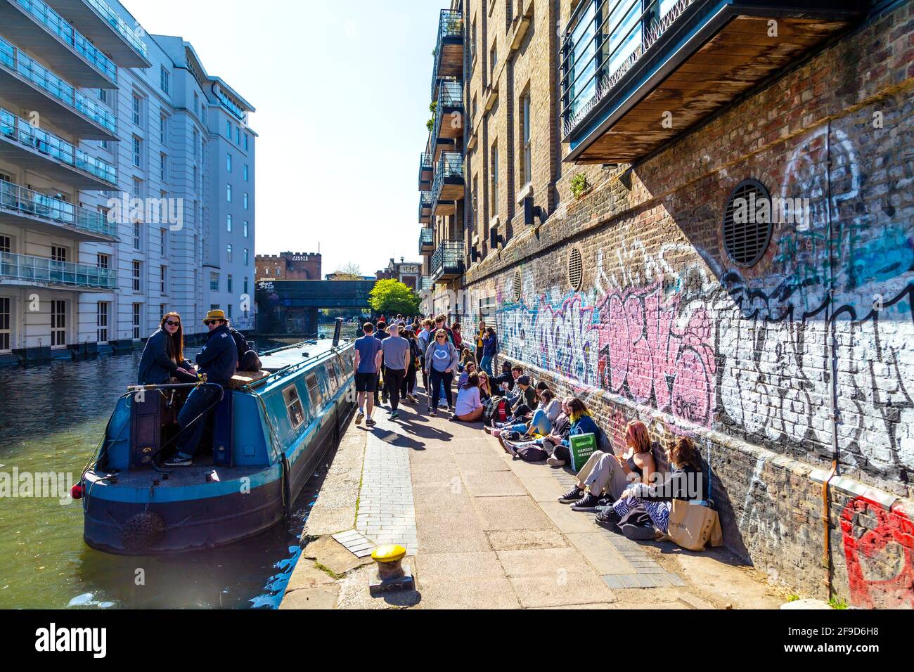 17. April 2021 - London, Großbritannien, Menschen sitzen an einem sonnigen Wochenende auf dem Treidelpfad entlang des Regent-Kanals in der Nähe des Camden Market, nachdem die Sperrung der Coronavirus-Pandemie gelockert wurde Stockfoto