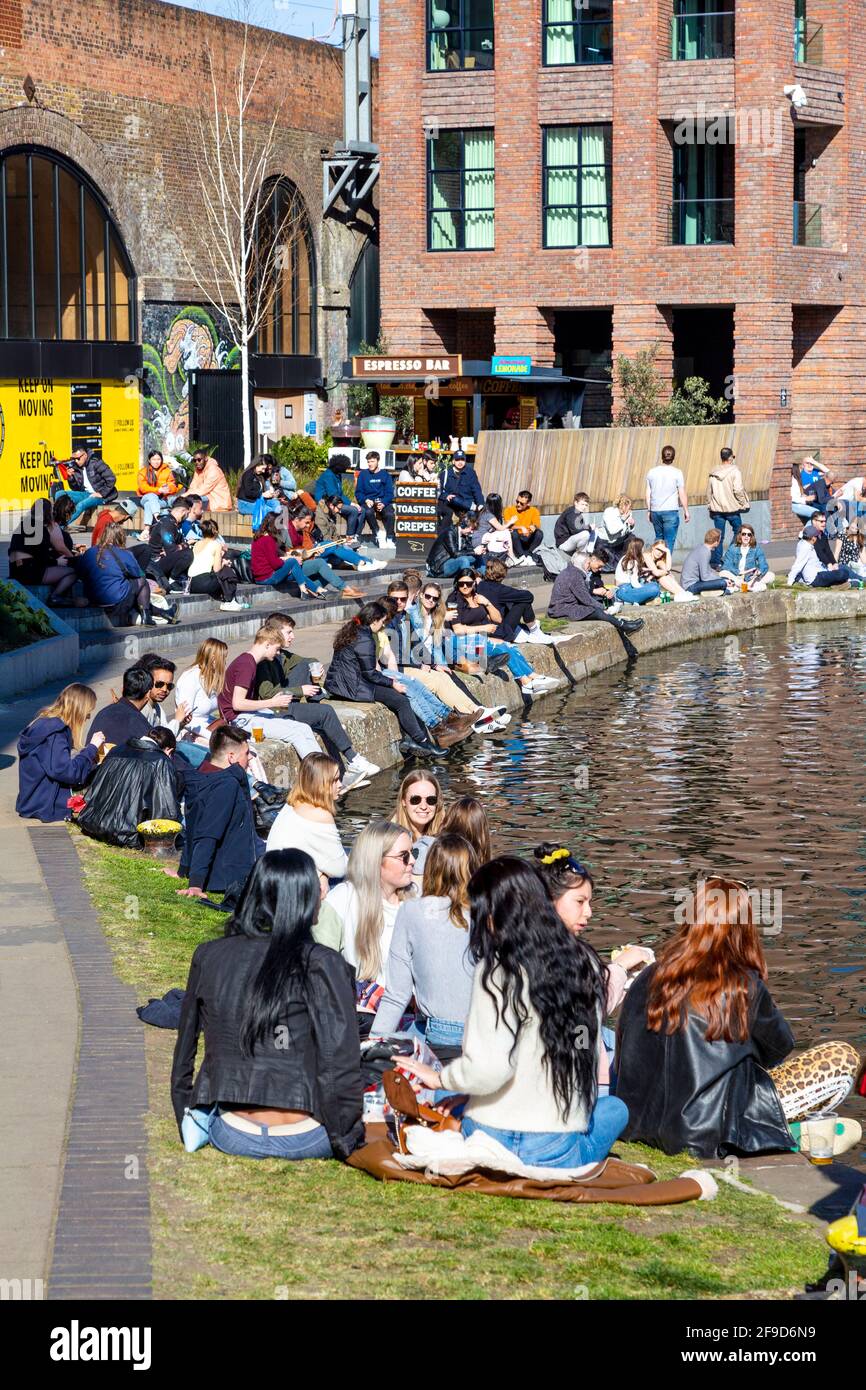 17. April 2021 - London, Großbritannien, Menschen, die an einem sonnigen Wochenende am Regents Canal in Camden sitzen, nachdem die Sperrung der Coronavirus-Pandemie gelockert wurde Stockfoto