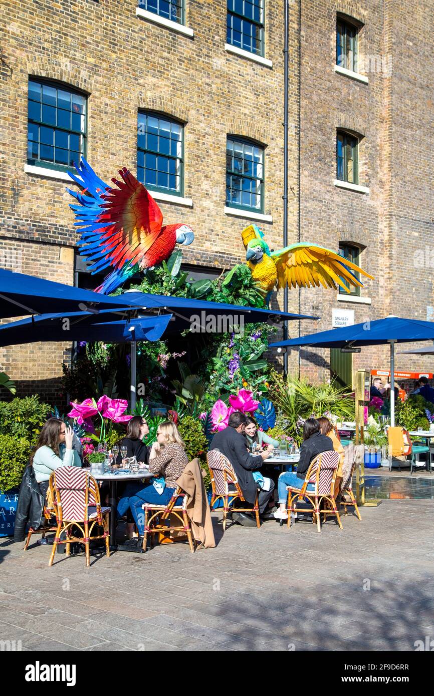 17. April 2021 - London, Großbritannien, Menschen essen an einem sonnigen Wochenende im Freien in einem Restaurant auf dem Granary Square, Kings Cross, nachdem die Sperrung der Coronavirus-Pandemie gelockert wurde Stockfoto