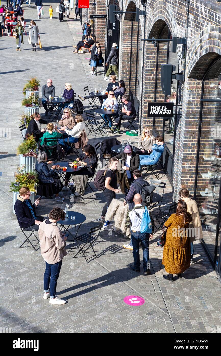 17. April 2021 - London, Großbritannien, Menschen essen an einem sonnigen Wochenende im Freien in einem Restaurant in Coal Drops Yard, Kings Cross, nachdem die Sperrung der Coronavirus-Pandemie gelockert wurde Stockfoto