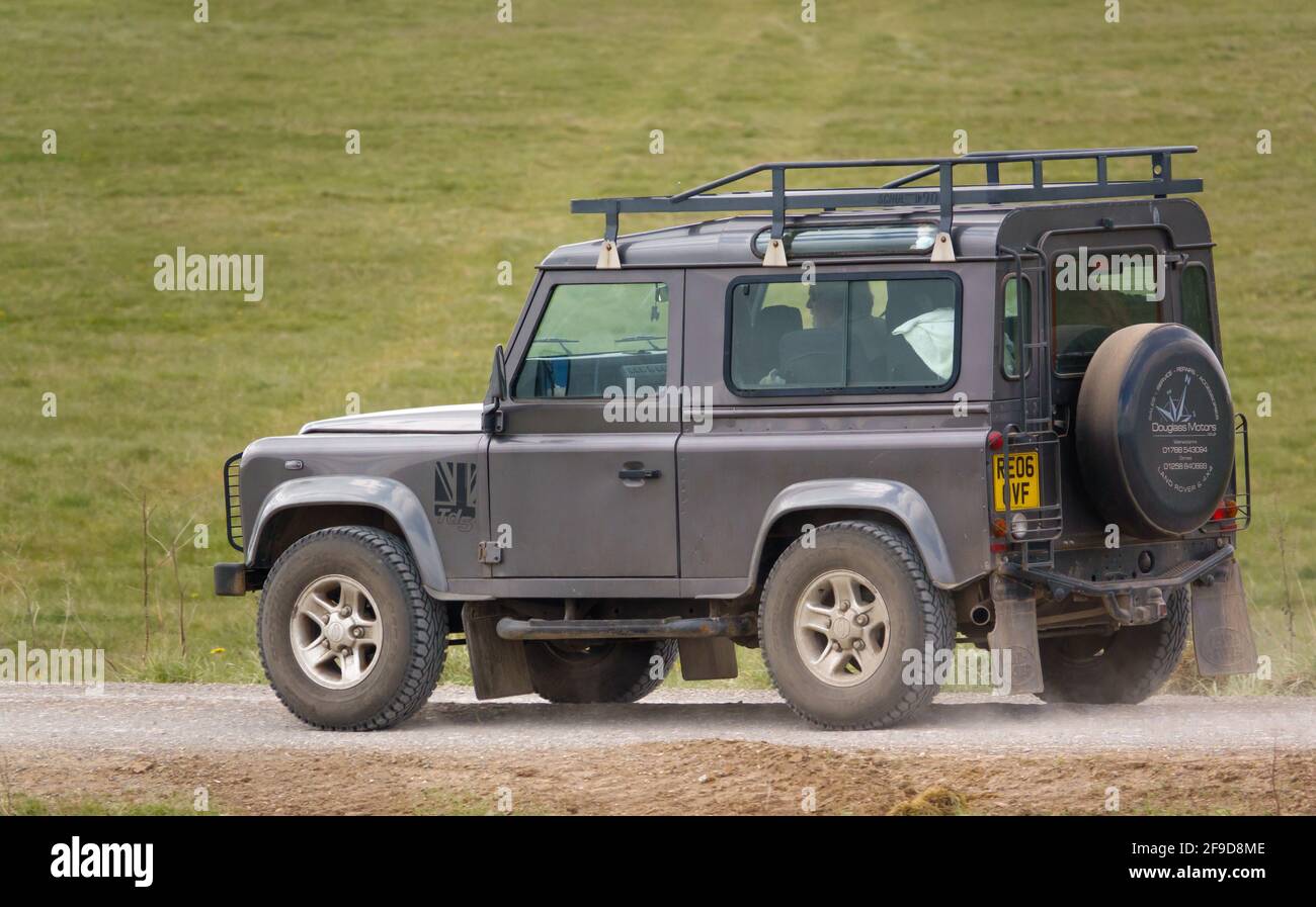 Ein graues Land Rover Defender 90 SWB Geländewagen Fahrt auf einer staubigen Steinspur Stockfoto