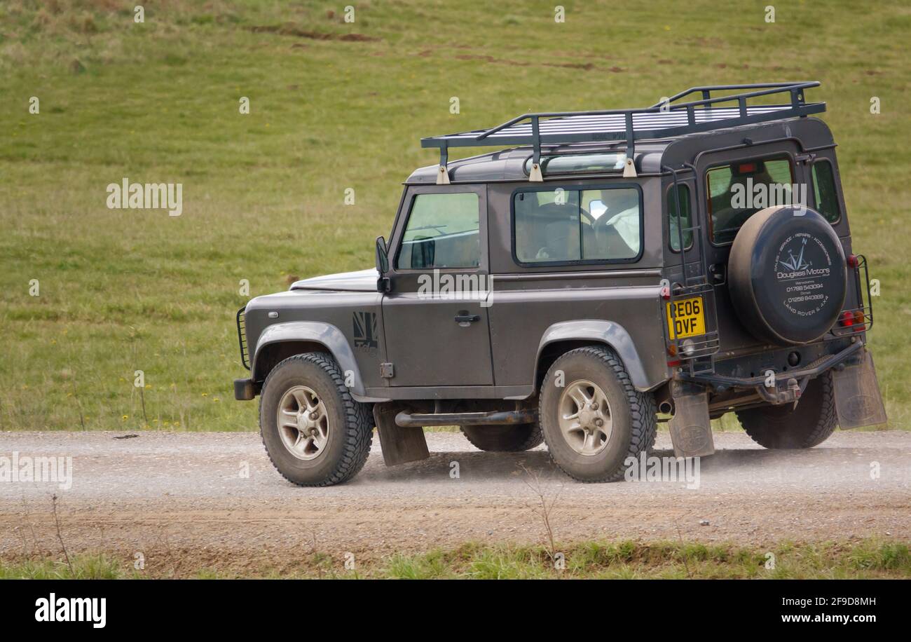 Ein graues Land Rover Defender 90 SWB Geländewagen Fahrt auf einer staubigen Steinspur Stockfoto
