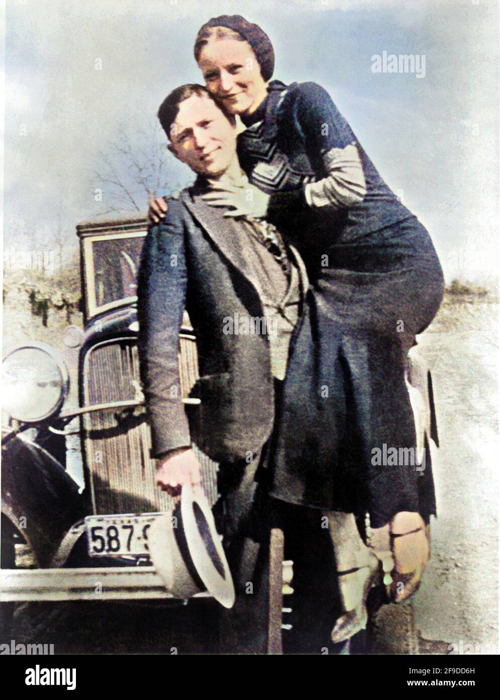 1934 , Arkansas , USA : die berühmten Gangsterne BONNIE PARKER ( 1910 - 1934 ) und CLYDE BARROW ( 1909 - 1934 ). Entgegen der landläufigen Meinung haben die beiden nie geheiratet. Sie waren in einer langjährigen Beziehung. Vor einem Ford V8-Automobil von 1932 posiert, wo Bonnie und Clyde am 23. Mai 1934 starben. Unbekannter Fotograf. DIGITAL EINGEFÄRBT . - OUTLAWS - KILLER - ASSASSINO - delinquente - criminalità organizzata - GANGSTERN - Bos - CRONAKA NERA - CRIMINALE - Auto - Automobil - Hut - cappello --- Archivio GBB Stockfoto