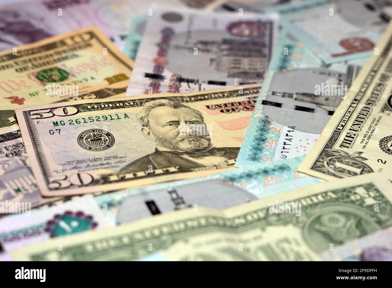 Ägyptische Landeswährung mit US-Dollar-Banknoten im Hintergrund. Geldscheine. Ägyptische Pfund-Banknoten und amerikanische Dollar-Rechnungen Hintergrund. Stockfoto