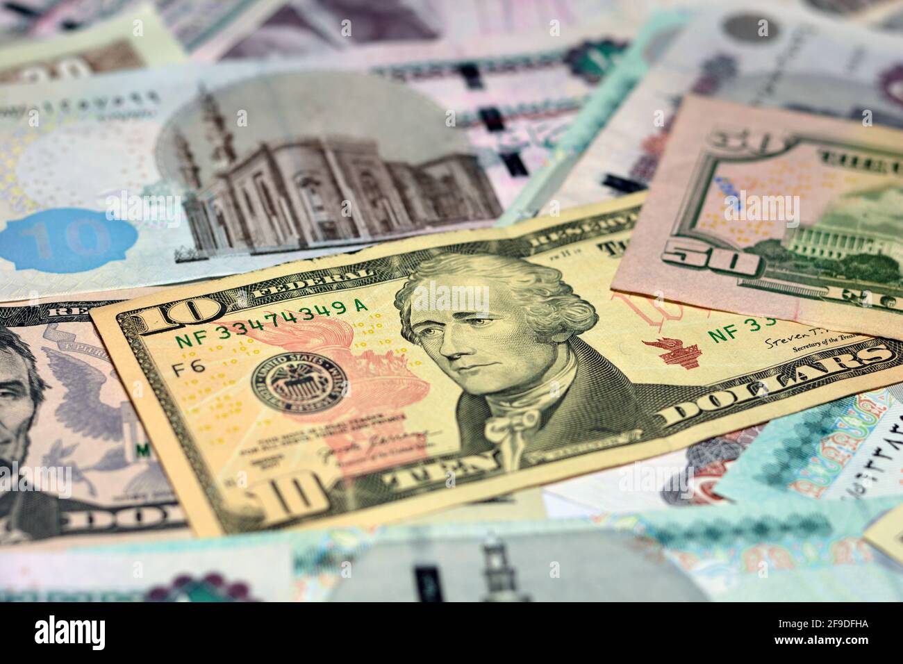 Ägyptische Landeswährung mit US-Dollar-Banknoten im Hintergrund. Geldscheine. Ägyptische Pfund-Banknoten und amerikanische Dollar-Rechnungen Hintergrund. Stockfoto