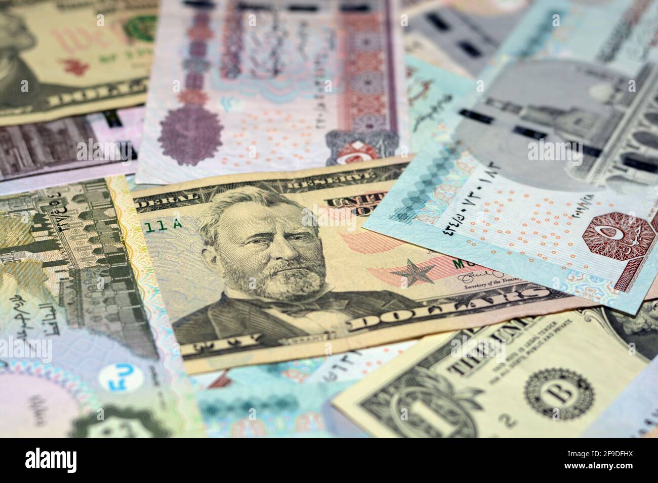 Ägyptische Landeswährung mit US-Dollar-Banknoten im Hintergrund. Geldscheine. Ägyptische Pfund-Banknoten und amerikanische Dollar-Rechnungen Hintergrund. Stockfoto