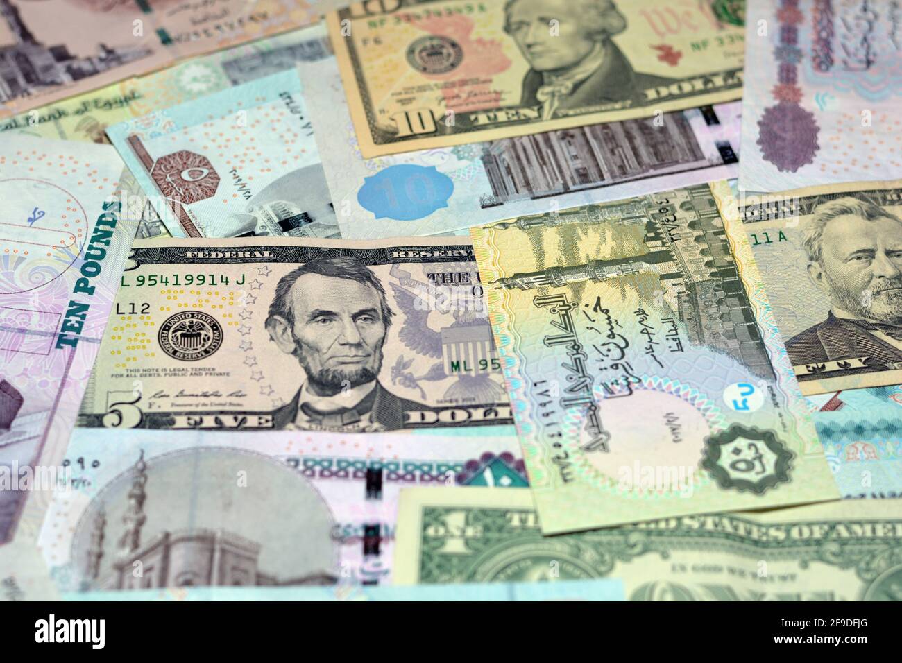 Ägyptische Landeswährung mit US-Dollar-Banknoten im Hintergrund. Geldscheine. Ägyptische Pfund-Banknoten und amerikanische Dollar-Rechnungen Hintergrund. Stockfoto