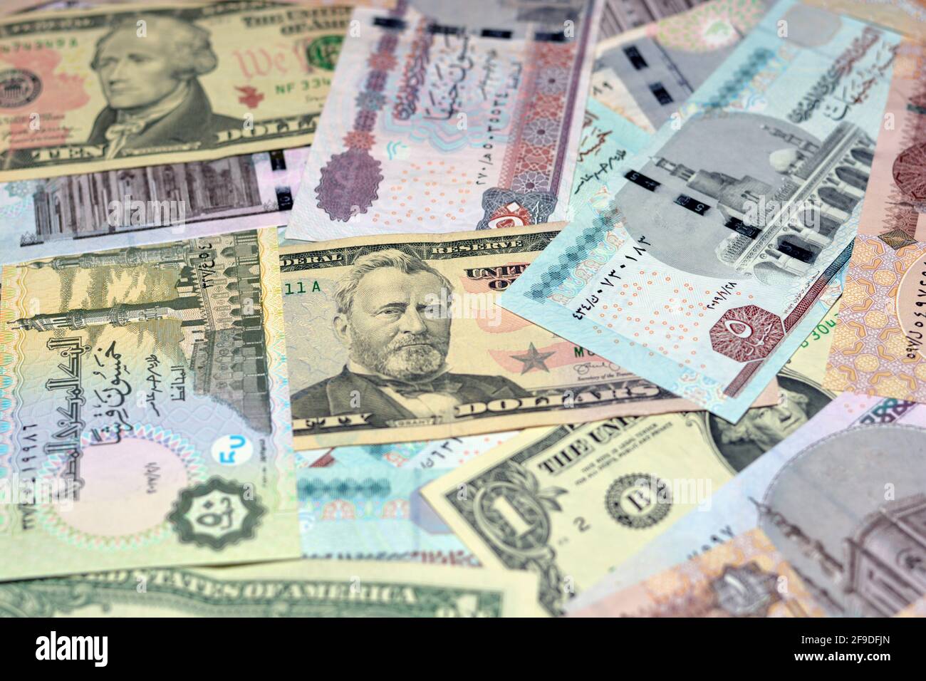 Ägyptische Landeswährung mit US-Dollar-Banknoten im Hintergrund. Geldscheine. Ägyptische Pfund-Banknoten und amerikanische Dollar-Rechnungen Hintergrund. Stockfoto