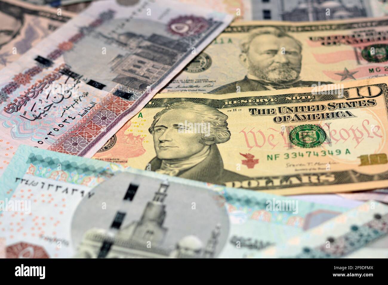 Ägyptische Landeswährung mit US-Dollar-Banknoten im Hintergrund. Geldscheine. Ägyptische Pfund-Banknoten und amerikanische Dollar-Rechnungen Hintergrund. Stockfoto