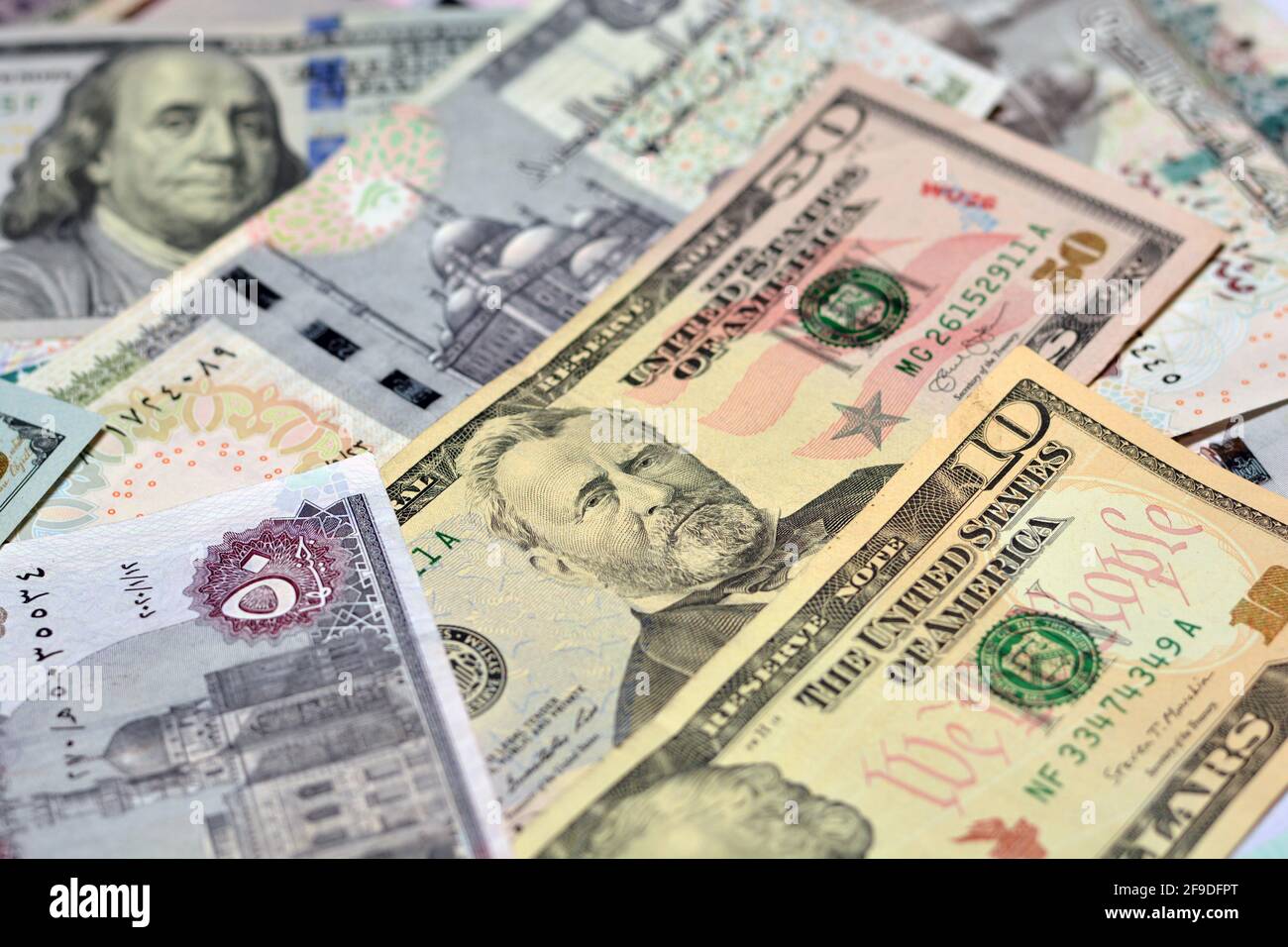Ägyptische Landeswährung mit US-Dollar-Banknoten im Hintergrund. Geldscheine. Ägyptische Pfund-Banknoten und amerikanische Dollar-Rechnungen Hintergrund. Stockfoto