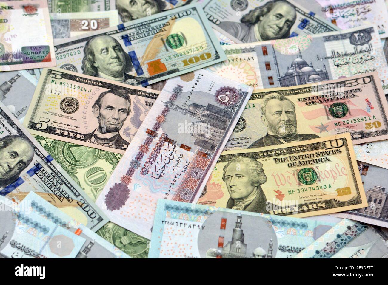 Ägyptische Landeswährung mit US-Dollar-Banknoten im Hintergrund. Geldscheine. Ägyptische Pfund-Banknoten und amerikanische Dollar-Rechnungen Hintergrund. Stockfoto