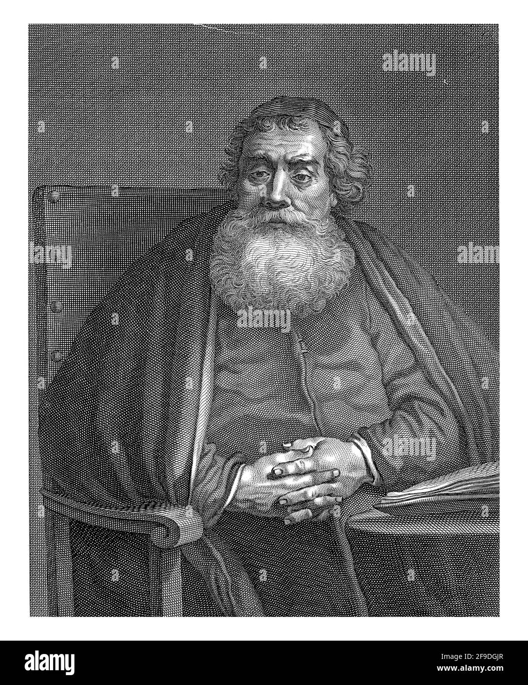 Sitzender Mann (Rabbiner) mit Bart, die Hände hinter dem Tisch zusammengekrallt Stockfoto