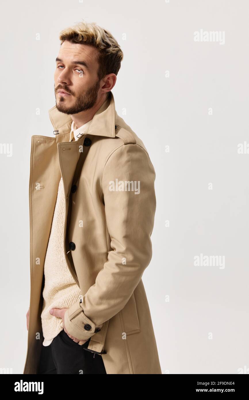 Gutaussehende Männer in beige Mantel Modell Pullover hellen Hintergrund  Stockfotografie - Alamy