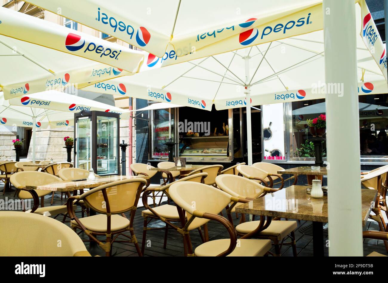 Restaurant mit Stühlen draußen, die auf Gäste warten, Pepsi Cola-Logo, das sichtbar ist Stockfoto